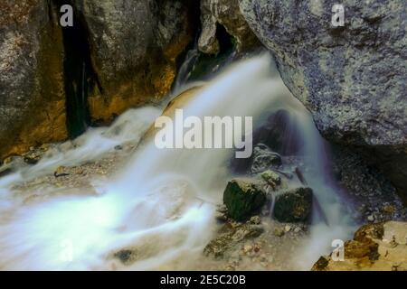 Wunderbar klarer Wasserfall mit Farben von der Sonne zwischen Felsen Stockfoto