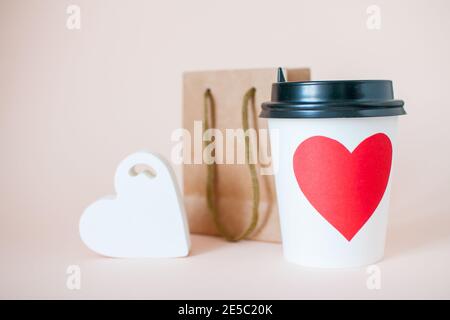 Papierbecher, Papiertüte und Herzfigur. Valentinstag Stockfoto