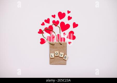 Geschenkpapierbeutel und rote Herzen fliegen aus ihm heraus. Valentinstag Stockfoto