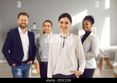 Portrait von glücklichen schönen Geschäftsfrau zusammen mit Team von Vielfältige Mitarbeiter Stockfoto