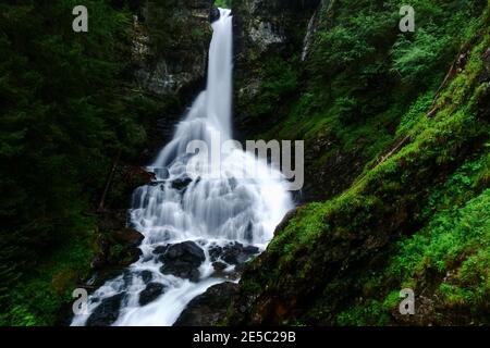 Wunderbarer großer weicher Wasserfall zwischen grünen Felsen in den Bergen Beim Wandern Stockfoto