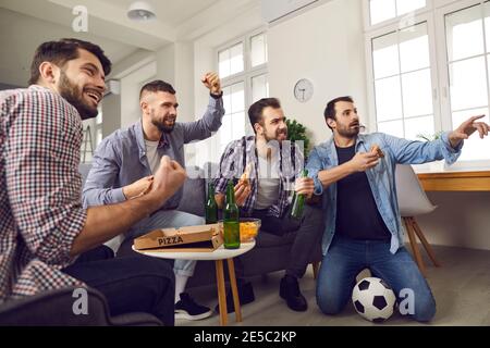 Eine Gruppe aufgeregter Männer mit Bier und Pizza beim Fußballschauen Spiel Stockfoto