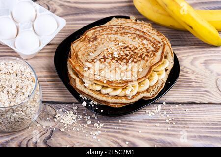 Haferpfannkuchen mit Banane. Schritt für Schritt Kochvorgang. Bananen mit Milch, Eiern und Hafer, Salz vermischen Stockfoto