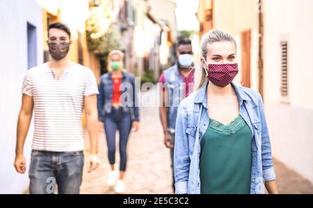 Multirassische Freunde gehen mit Gesichtsmaske nach Lockdown Wiedereröffnung - Neue normale Freundschaft Konzept mit Jungs und Mädchen verbringen Zeit Gemeinsam Stockfoto