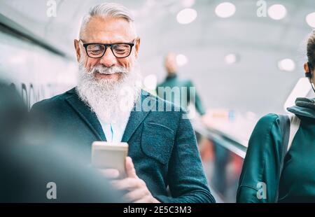 Hipster bärtiger Mann mit Handy im Einkaufszentrum Aufzüge - trendige alte Person, die Inhalte mit dem Smartphone teilt Stockfoto