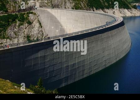 Wasserkraftwerk mit einem riesigen Damm und kleinen Menschen Auf sie in österreich Stockfoto