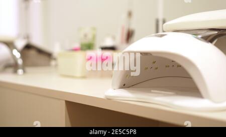 Nagellampe auf blauem Hintergrund im Salon. Für Text platzieren Stockfoto
