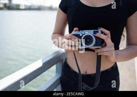 Nahaufnahme einer Frau, die die Kamera neben dem Fluss hält Stockfoto
