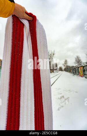 Weiß rot weiß gestrickter Schal in der Hand Stockfoto