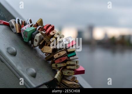 Vorhängeschlösser auf der Liebesschlösser-Brücke (Eiserner Steg, Eiserne Brücke) in Frankfurt am Main, in die verschiedene Namen von Liebespaaren eingraviert sind Stockfoto