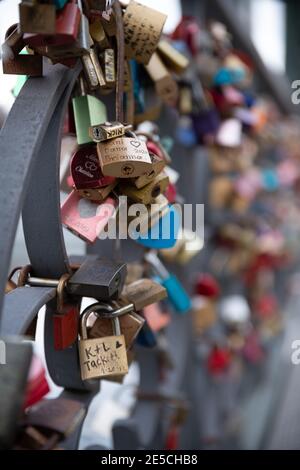 Vorhängeschlösser auf der Liebesschlösser-Brücke (Eiserner Steg, Eiserne Brücke) in Frankfurt am Main, in die verschiedene Namen von Liebespaaren eingraviert sind Stockfoto