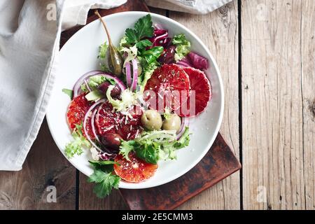 Sizilianischer Orangensalat. Salat mit Blutorange, roten Zwiebeln und Oliven, Draufsicht. Stockfoto