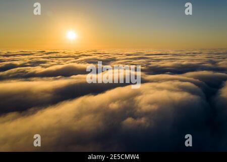 Beeindruckende Luftaufnahme des Sonnenuntergangs Himmel mit den Wolken unter uns. Die Schatten, die von der Sonne durch die Wolken projiziert werden, schaffen ein dramatisches lan Stockfoto