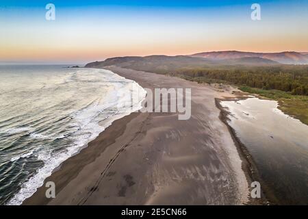 Atemberaubende Luftaufnahme eines traumhaften Strandes an der zentralen chilenischen Küste. Beeindruckende Aussicht auf die Wellen aus dem Meer und die wilde Küste. Ein „ein“ Stockfoto