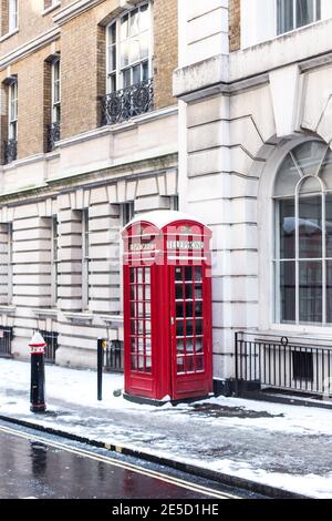 Rote Telefondose im Schnee, London, England, Großbritannien Stockfoto