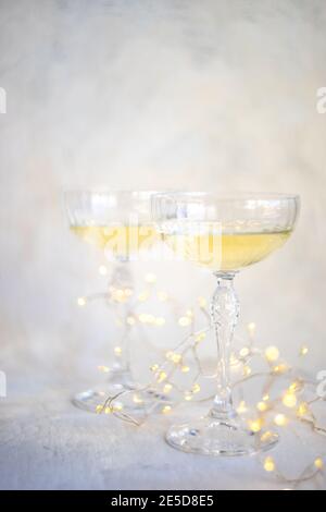 Zwei Gläser Champagner mit Lichterketten auf einem Tisch Stockfoto