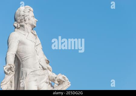 Warmer Sonnenuntergang über dem Mozart-Denkmal vor dem Palmenhaus, in der Nähe der Neuen Burg und der Hofburg, in der historischen Innenstadt von Wien, Österreich bei Sonnenschein Stockfoto