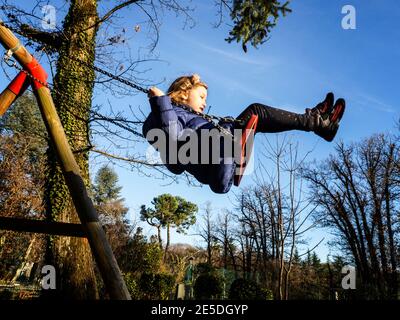 Mädchen schwingt auf einer Schaukel auf einem Spielplatz, Italien Stockfoto