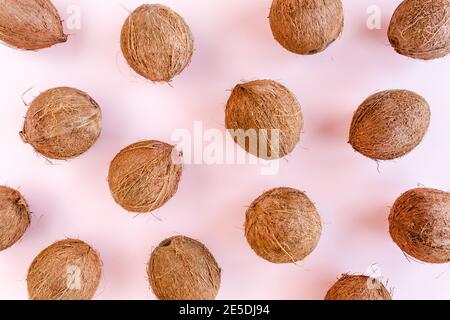 Muster, Textur mit Kokosnüssen und tropischen Palmenblättern auf rosa Hintergrund. Tropischer abstrakter Hintergrund. Flach liegend, Draufsicht. Stockfoto