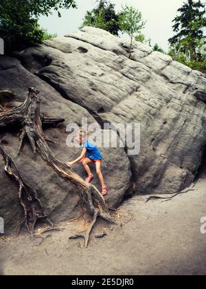 Mädchen klettern auf Felsen, Nationalpark Stolowe Berge, Polen Stockfoto