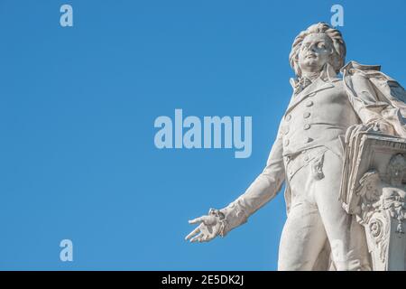 Warmer Sonnenuntergang über dem Mozart-Denkmal vor dem Palmenhaus, in der Nähe der Neuen Burg und der Hofburg, in der historischen Innenstadt von Wien, Österreich bei Sonnenschein Stockfoto