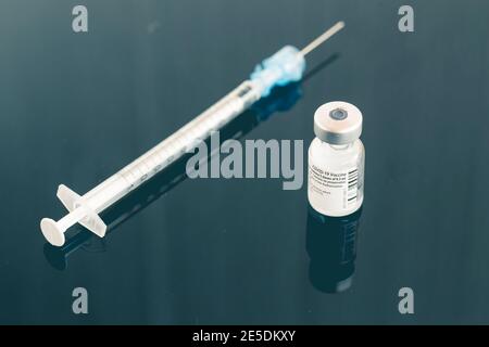 Ein Fläschchen des Coronavirus-Impfstoffs und eine Spritze auf einem Tisch in einer Klinik Stockfoto