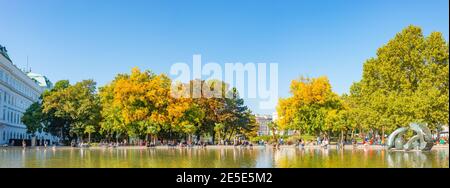 Panoramablick über Brunnen und Park am St. Karl Dom in Wien im Herbst Farben, Österreich, bei direkter Sonneneinstrahlung Stockfoto