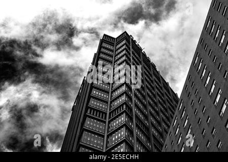 Blick auf einen Wolkenkratzer gegen wispy Wolken in schwarz Und weiß Stockfoto