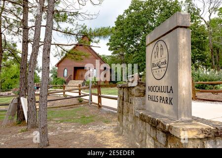 Gadsden, Alabama, USA - 20. Mai 2017: Noccalula Falls Park Schild mit Kapelle im Hintergrund. Stockfoto