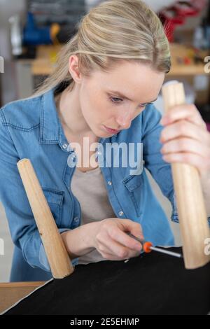 Frau bei der Montage von Holzmöbeln Stockfoto