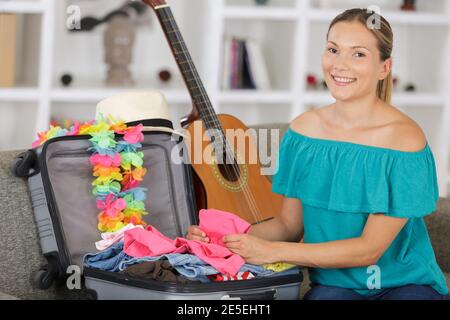 Junge Frau, die ihren Koffer packt Stockfoto