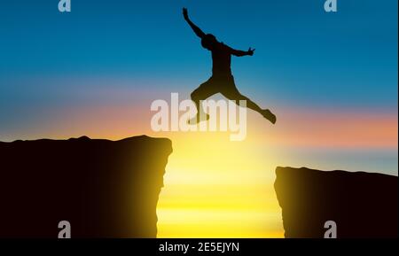 Die Silhouette eines Mannes, der über den Abgrund springt Die Zeit der Sonne untergehen Konzept des Sieges und Erfolg Stockfoto