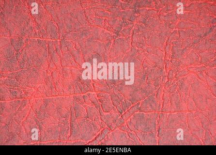 Ein Fragment aus echtem Leder mit Falten, künstlich in Burgunder Farbe gefärbt. Hintergrund, Muster, Textur. Stockfoto