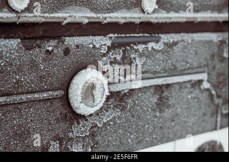 Winterszene mit morgendlichen Kristallen, die über ein Metall fächeln Mailbox und Abdeckung des Schlosses Stockfoto