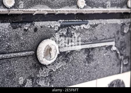 Winterszene mit morgendlichen Kristallen, die über ein Metall fächeln Mailbox und Abdeckung des Schlosses Stockfoto