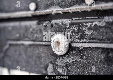 Winterszene mit morgendlichen Kristallen, die über ein Metall fächeln Mailbox und Abdeckung des Schlosses Stockfoto