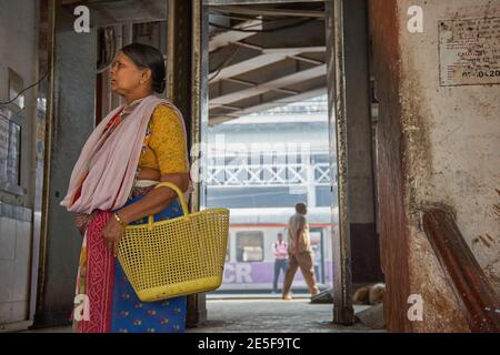 Nach dem Aussteigen aus einem Vorstadtzug verlässt eine Hausfrau aus Mumbai Chhatrapati Shivaji Maharaj Terminus in Mumbai, dem verkehrsreichsten Bahnhof der Stadt Stockfoto