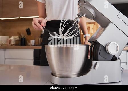 Frau, die Küchenmaschine benutzt, um in der Küche zu kochen Stockfoto