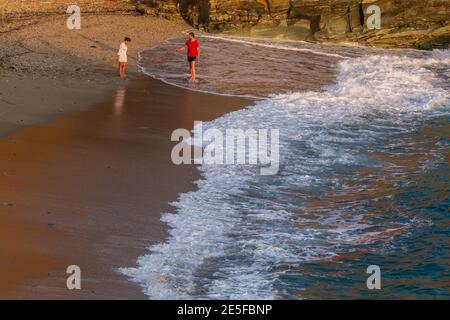 Agkali Beach, Folegandros Island, Griechenland - 24 September 2020: Touristen bleiben und entspannen am Strand. Beliebter Sandstrand. Stockfoto