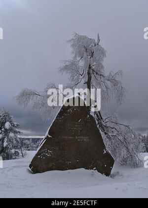 Großer Gedenkstein (Sandsteinfelsen) zum Gedenken an Bundesvater Dinkelacker, Gründer des Schwäbischen Skiverbandes in der Wintersaison mit Schnee. Stockfoto