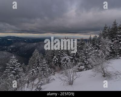 Atemberaubende Winterlandschaft mit gefrorenen Bäumen und Panoramablick über schneebedeckte Schwarzwälder Hügel mit Rheintal und Vogesen Berge. Stockfoto