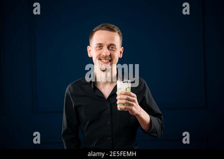 Junger Mann mit einem Glas Gin Tonic-Cocktail Stockfoto