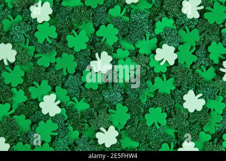 Shamrock Konfetti Textur Hintergrund mit grünen und weißen Glücksklebern Stockfoto