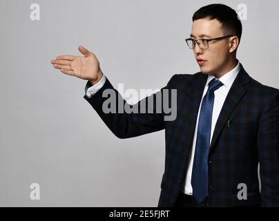 Porträt des asiatischen Geschäftsmann Experte Analyst in offiziellen Anzug, Krawatte und Brille zeigt Richtung mit seiner Hand Stockfoto