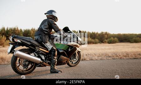Sportfahrrad Fahrer trägt einen Helm und Leder Schutzausrüstung Auf einem schnellen Sportfahrrad Stockfoto