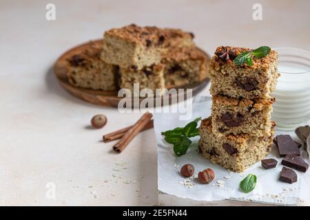 Haferflocken Quadrate mit Schokolade, Nüsse, Stücke von Schokolade und Minze, hellen Beton Hintergrund. Diät-Bars. Gesunde Bäckerei zum Frühstück oder Dessert. Sel Stockfoto