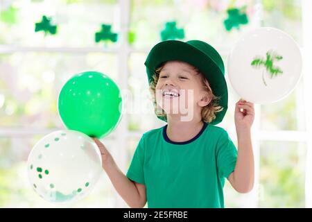 Familie feiert St. Patrick's Day. Irischer Urlaub, Kultur und Tradition. Kinder tragen grünen Leprechaun Hut und Bart mit Irland-Fahne und Kleeblatt Stockfoto