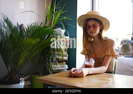 Die Frau in der Bibliothek sitzt am Tisch und liest Freizeit Innen Stockfoto
