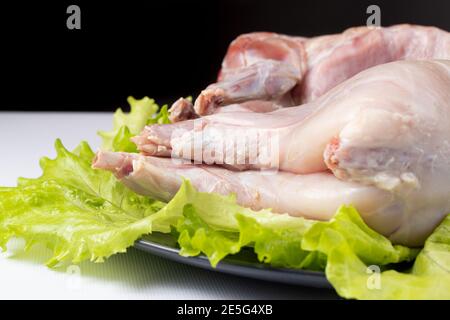 Rohes Kaninchenfleisch, Kochfleisch, Fleisch auf Salat. Stockfoto