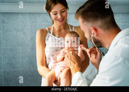 Mutter hält Baby für Kinderarzt Arzt zu untersuchen Stockfoto